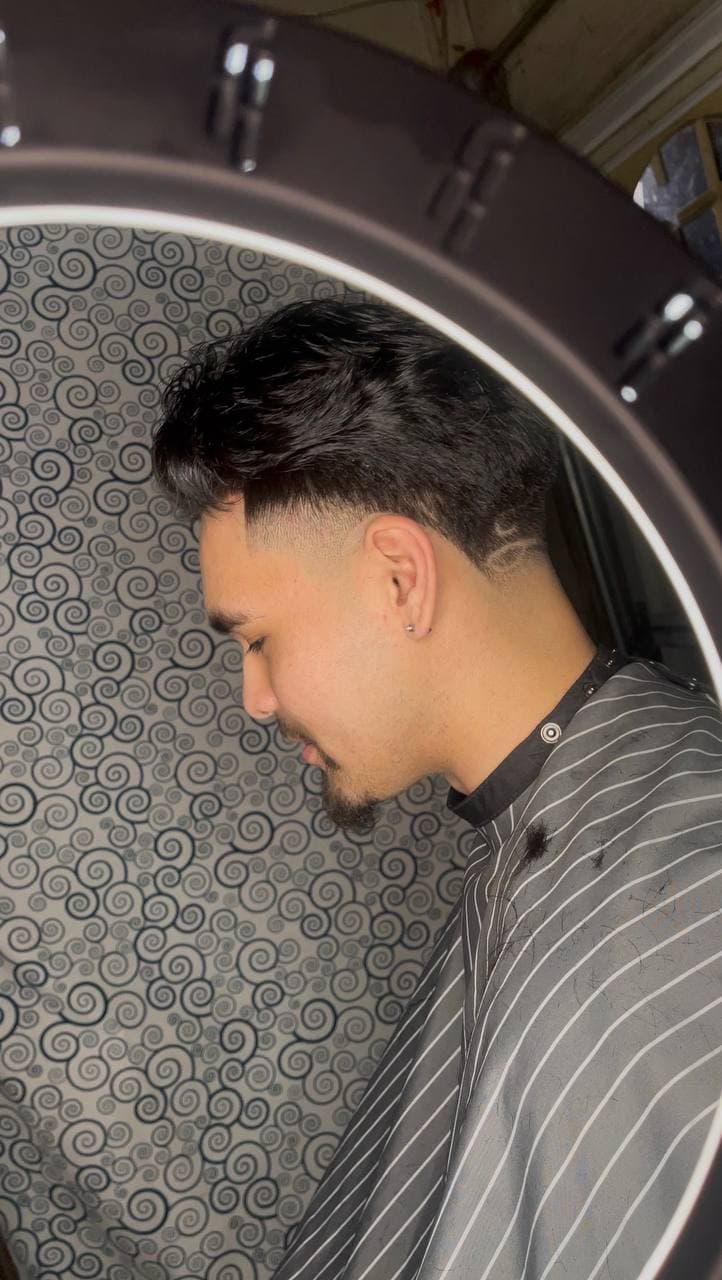 Client in the chair with a clean KVN Blendz fade framed by a ring light