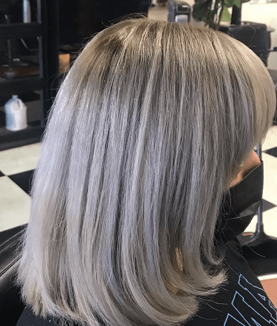 Silver blonde layered bob haircut in a salon chair