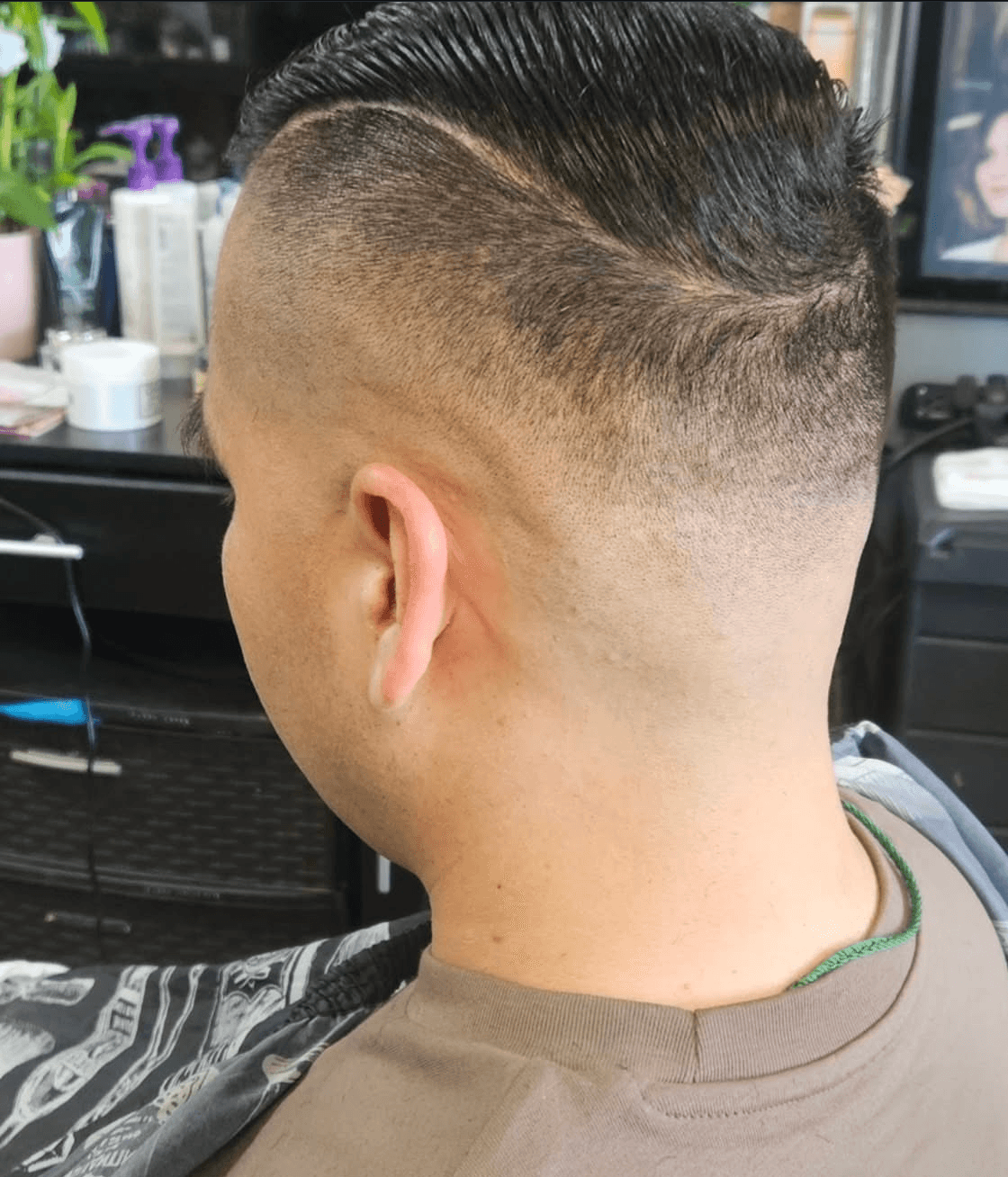Slick back haircut with hard part and clean fade